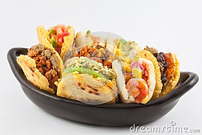 Arepas with assorted fillings served in a black ceramic dish Stock Photo