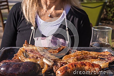 Argentine barbecue and a woman in the background out of focus Stock Photo