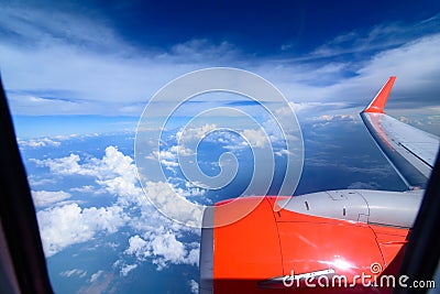 Clouds in the sky and cityscapes though airplane window. Red aeroplane flying Stock Photo