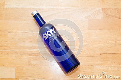 Skyy Vodka blue bottle on a wooden table laying down Editorial Stock Photo