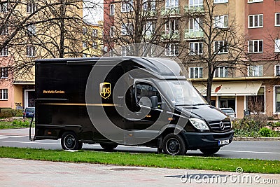 Ark brown Mercedes-Benz Sprinter van on a street delivering a package Editorial Stock Photo