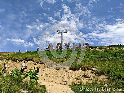 Arkhyz, Karachay-Cherkessia, Russia - August 21, 2022: People climb the mountain to the installation called Arkhyz. Translation: Editorial Stock Photo