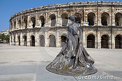 Arles, France - July 15, 2013: Roman Arena (Amphitheater) in Arles and bullfighter sculpture, Provence, France Stock Photo