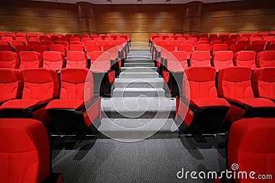 Arm-chairs and gangway are in empty hall Stock Photo