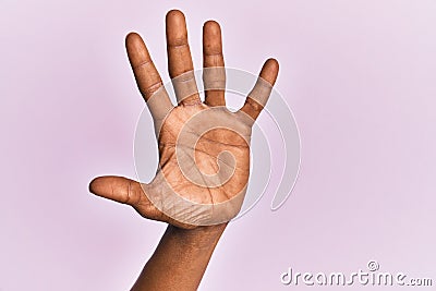 Arm and hand of black middle age woman over pink isolated background counting number 5 showing five fingers Stock Photo
