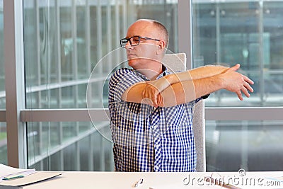 Arm-neck stretching in office Stock Photo