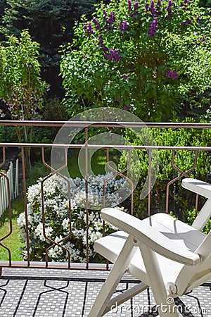 Armchair on the balcony in front of the garden Stock Photo