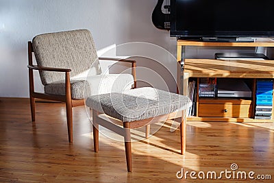 Armchair with Ottoman Danish Design in a Cosy Modern Furnished Living Room 60s Style Interior with a Wall Shelf and a Typewriter Stock Photo