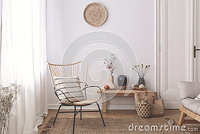 Armchair with pillow on brown rug in white natural living room interior with plants. Real photo Stock Photo