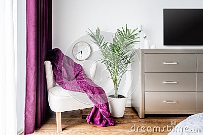 Purple blanket and a wall clock as decor in modern, stylish bedroom Stock Photo