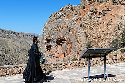 Armenia, Noravank, September 2022. Armenian priest with a child against the backdrop of mountains in the monastery. Editorial Stock Photo