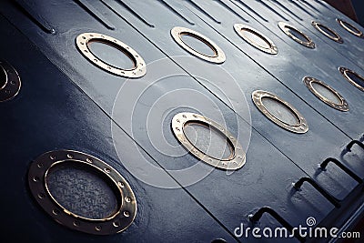Armored portholes of brass with brass screws. Stock Photo