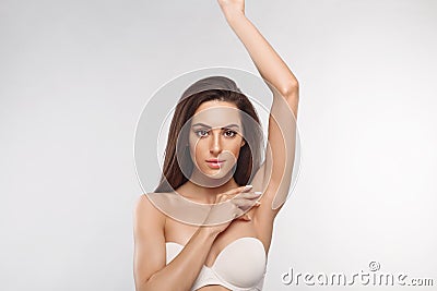 Armpit epilation, lacer hair removal. Young woman holding her arms up and showing clean underarms, depilation smooth clear skin .B Stock Photo