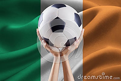 Arms holding ball with flag of Ireland Stock Photo