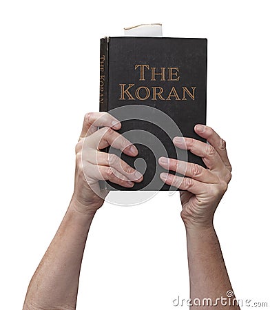 Arms raised into the air with hands reaching up holding the muslim Koran holy book of Islam Stock Photo