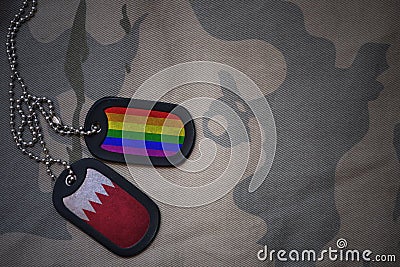 army blank, dog tag with flag of bahrain and gay rainbow flag on the khaki texture background. Stock Photo