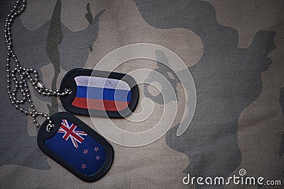 army blank, dog tag with flag of russia and new zealand on the khaki texture background. Stock Photo