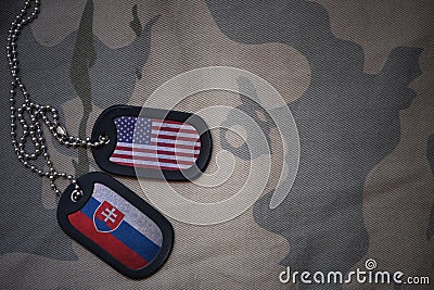 army blank, dog tag with flag of united states of america and slovakia on the khaki texture background. Stock Photo