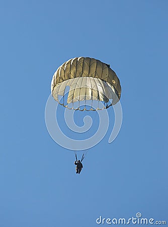 Army paratrooper floating to the ground below a parachute Editorial Stock Photo