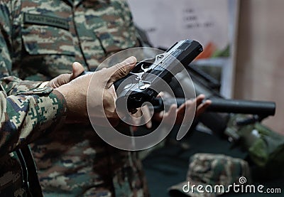 An army personnel looks a gun displayed at a stall during ' East Tech 2023' , hosted by The Eastern command of the India Editorial Stock Photo