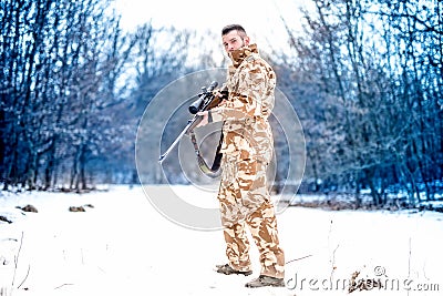 Army sniper during military operation using a professional rifle on a cold winter day Stock Photo