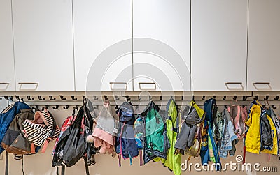 ARNHEM / NETHERLANDS - AUGUST 28 2020: Cloakroom with coats and backpacks in a school building for toddlers and young children Editorial Stock Photo