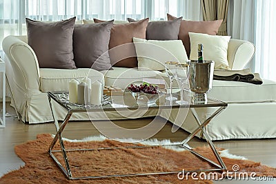 Aroma candles and wine glasses on the table with beige sofa and Stock Photo