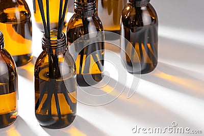 Aroma diffuser with essential oil in a Amber, brown glass bottle. Creative trendy image, Caustics formed by the refraction of the Stock Photo