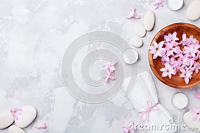 Aromatherapy, beauty, spa background with massage pebble, perfumed flowers water and candles on stone table top view. Flat lay. Stock Photo