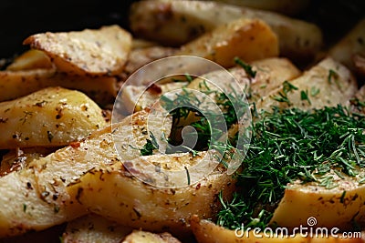 Aromatic baked potato wedges with fresh dill herbs. Homemade rustic dish, delicious hearty food close up Stock Photo