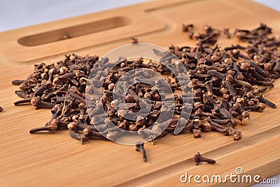 Aromatic cloves magnified on a wooden kitchen board, spices and aromas. Large depth of field Stock Photo