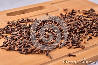 Aromatic cloves magnified on a wooden kitchen board, spices and aromas. Large depth of field Stock Photo