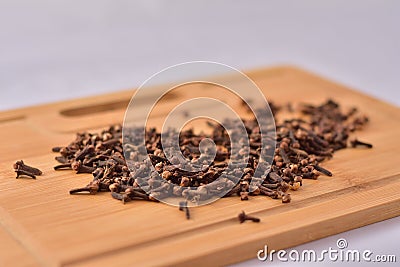 Aromatic cloves magnified on a wooden kitchen board, spices and aromas. Shallow depth of field Stock Photo