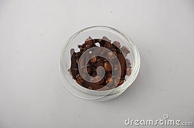 Aromatic cloves on white glass bowl with white background. Stock Photo