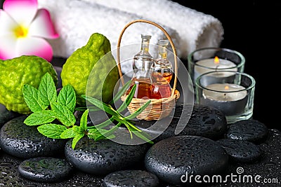 Aromatic concept of bergamot fruits, fresh mint, rosemary, candles, towels, flower and bottles essential oil on zen stones Stock Photo