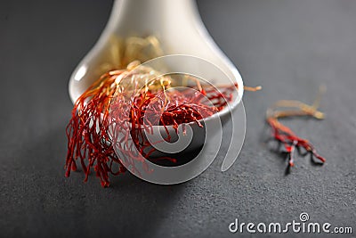 Exotic saffron strings in a white spoon. Stock Photo