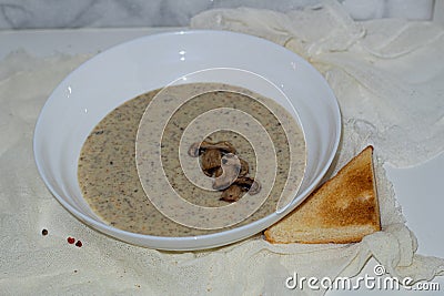 Aromatic mushroom cream soup with champignons. Fresh vegetables and freshly baked bread. A hearty and delicious lunch. Stock Photo