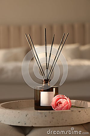 Aromatic reed air freshener and flower on bench in bedroom Stock Photo