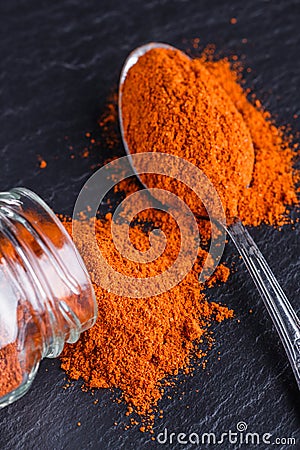 Aromatic spicy chilli powder on a dark stone background Stock Photo