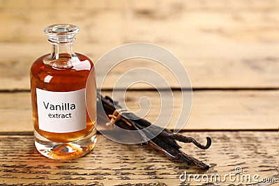 Aromatic vanilla extract and beans on wooden table, space for text Stock Photo