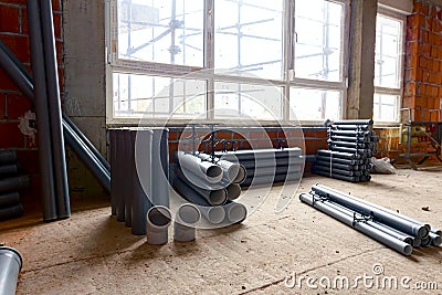 Pile of sewerage tubes placed on the floor in the unfinished residential edifice Stock Photo