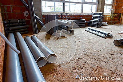 Pile of sewerage tubes placed on the floor in the unfinished residential edifice Stock Photo