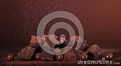 Arrangement of pieces of chocolate and round candies sprinkled with cocoa powder on brown Stock Photo