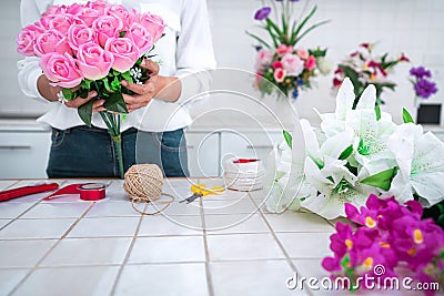 Arranging artificial flowers decoration at home, Young woman florist work making organizing diy artificial flower, craft and hand Stock Photo