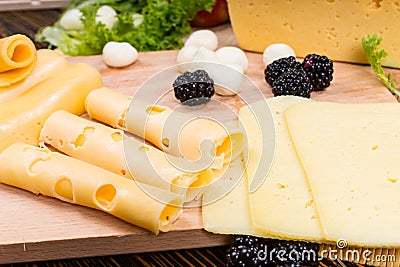 Arranging slices of assorted cheeses on a board Stock Photo