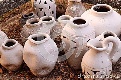 Array of ceramic vases positioned outdoors on a layer of soil Stock Photo
