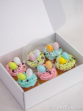 Array of colorful Easter cupcakes in a white box. Stock Photo