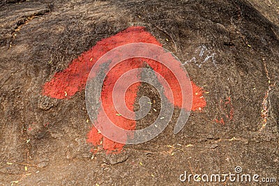 Arrow on a rock showing the direction of a hiking trail. Pidurangala rock, Sri Lank Stock Photo