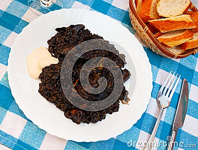 Arroz negro - spanish recipe, black paella with cuttlefish on plate Stock Photo