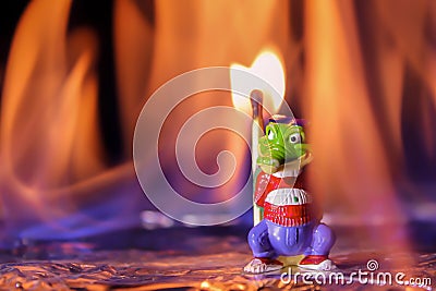 Arsonist on fire. A crocodile toy stands with a match in a fiery flame. Fire and fire concept Stock Photo